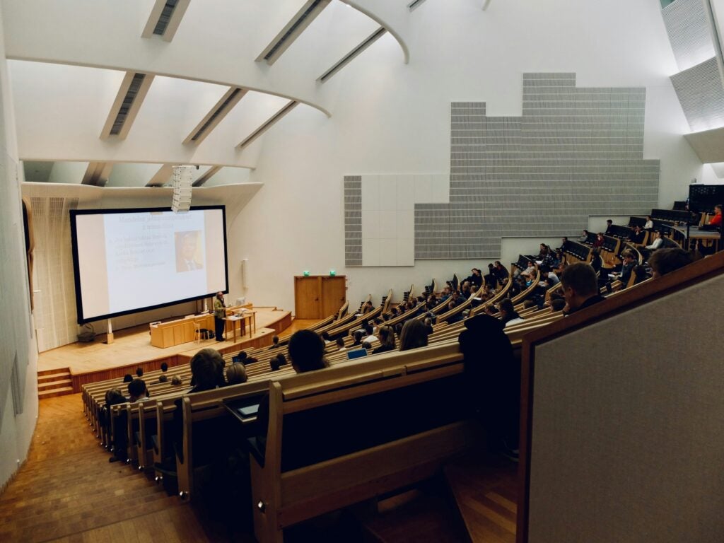 A lecture hall with people listening to a speaker.