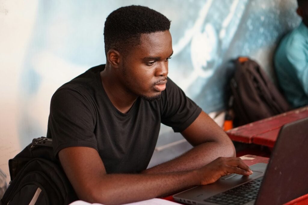 A young man working on a laptop.